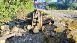 Caption: Kondisi pekerjaan proyek pembangunan plengsengan jalan di Desa Baruh (Sumber Foto: Agus Junaidi/Pilar Pos)