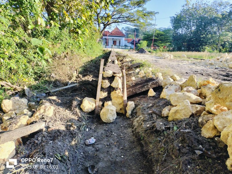 Caption: Kondisi pekerjaan proyek pembangunan plengsengan jalan di Desa Baruh (Sumber Foto: Agus Junaidi/Pilar Pos)