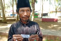 Zainudin, salah seorang pengunjung wisata Pantai Slopeng Kabupaten Sumenep menujukan karcis parkir foto copy di lokasi, Kamis, 17/06/2025.