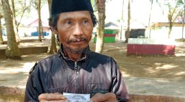 Zainudin, salah seorang pengunjung wisata Pantai Slopeng Kabupaten Sumenep menujukan karcis parkir foto copy di lokasi, Kamis, 17/06/2025.
