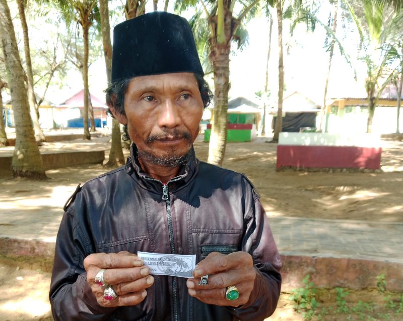 Zainudin, salah seorang pengunjung wisata Pantai Slopeng Kabupaten Sumenep menujukan karcis parkir foto copy di lokasi, Kamis, 17/06/2025.