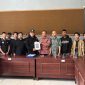Caption: Hanafi, Ketua Cabang PSHT Sampang Jaket Hitam Saat Menyerahkan Berkas Pembaruan Legalitas Kepada Bambang, Kabid Politik Dalam Negeri Bakesbangpol Kabupaten Sampang