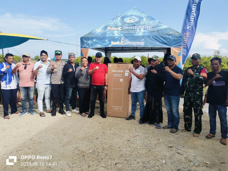Caption: Rudi Kurniawan, Ketua DPRD Sampang (Kaos Merah) Saat Memberikan Sumbangan Hadiah di Tempat Lomba Pacu Perahu Dayung Kulkas Dua Pintu (Sumber Foto: Agus Junaidi/Pilar Pos)