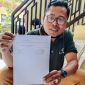 Caption: Ketua LSM AWPM Imam Syafi’i Memegang Bukti Tanda Terima Laporan usai melapor ke Polres Pamekasan, Senin (01/09/2025)