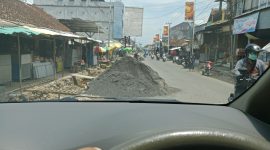 Terlihat jelas tumpukan bahan material batu dan pasir memakan separuh jalan sehingga membahayakan pengendara yang lewat, Jumat, 21/11/2025