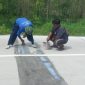 Caption: Rekanan CV Kencana Bahari Saat Perbaiki Proyek Peningkatan Jalan Labuhan-Sreseh yang Rusak (Sumber Foto: dok/Pilar Pos)