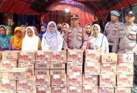 Kapolsek Pasean AKP Gunarto, SM (Tengah) didampingi Kepala Desa Sana Daya saat menyerahkan bantuan sembako kepada warga terdampak bencana, Jum'at, 23/01/2026.