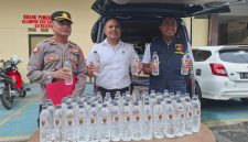 Caption: Kasat Reskrim Polres Sampang, Iptu Nur Fajri Alim, di Tengah Menggunakan Baju Putih Memperlihatkan Botol Miras Arak Bali (Sumber Foto: Humas Polres Sampang/dok Pilar Pos)