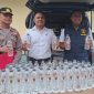 Caption: Kasat Reskrim Polres Sampang, Iptu Nur Fajri Alim, di Tengah Menggunakan Baju Putih Memperlihatkan Botol Miras Arak Bali (Sumber Foto: Humas Polres Sampang/dok Pilar Pos)
