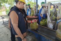 Caption: Kanit Tipidsus Satreskrim Polres Sampang, Muammar Amin, Saat Melakukan Pengecekan LPG 3 Kg di SPBE PT Asa Perkasa Abimulya di Jalan Raya Camplong, Kabupaten Sampang (Sumber Foto: Humas Polres Sampang/Pilar Pos)