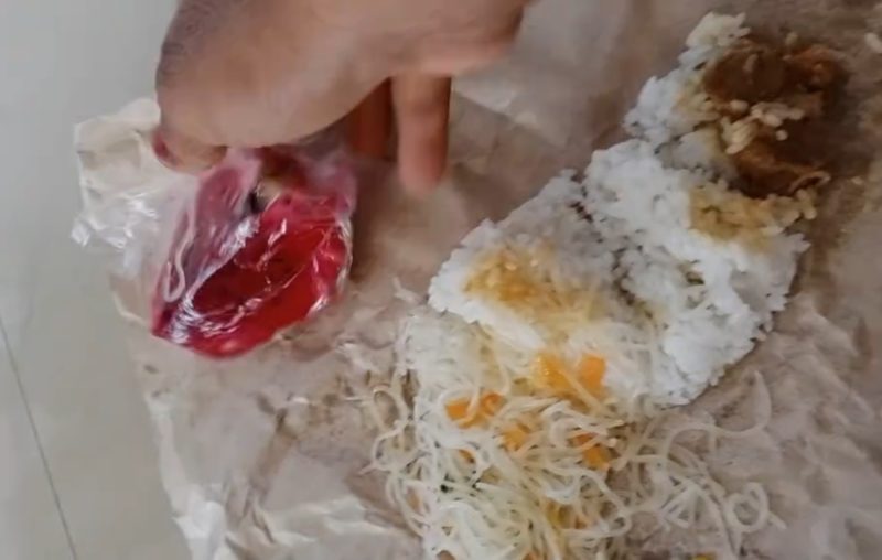 Caption: Screenshot Video Paket MBG Menu SPPG di Desa Sreseh, Berbungkus Kertas Yang disalurkan oleh Kader dari Salah-satu Posyandu di Dusun Tasolong (Sumber Foto: Screenshot Video Milik Warga/dok Pilar Pos)