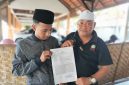 Caption: Abrori (Pelapor) Didampingi Habib Yusuf, Memperlihatkan Surat Tanda Terima Pengaduan Pelaporan Usai Laporan ke Polres Sampang (Sumber Foto: Agus Junaidi/Pilar Pos)