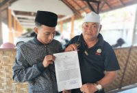 Caption: Abrori (Pelapor) Didampingi Habib Yusuf, Memperlihatkan Surat Tanda Terima Pengaduan Pelaporan Usai Laporan ke Polres Sampang (Sumber Foto: Agus Junaidi/Pilar Pos)