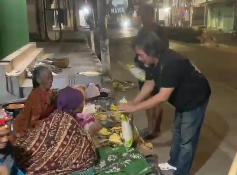 Caption: Katim URC Aiptu Achson Yudianto, didampingi personel URC Satreskrim Polres Sampang saat bagikan beras kepada pedagang pisang di pinggir jalan perkotaan Kabupaten Sampang (Sumber Foto: Screenshot Video Kegiatan Sosial URC Satreskrim Polres Sampang For Pilar Pos)