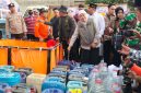 Caption: Gubernur Jatim, Khofifah Indar Parawansa, didampingi Bupati Sampang H. Slamet Junaidi mendistribusikan langsung bantuan air bersih terhadap warga terdampak kekeringan di wilayah Desa Kedungdung (Sumber Foto: Agus Junaidi/Pilar Pos)