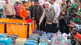 Caption: Gubernur Jatim, Khofifah Indar Parawansa, didampingi Bupati Sampang H. Slamet Junaidi mendistribusikan langsung bantuan air bersih terhadap warga terdampak kekeringan di wilayah Desa Kedungdung (Sumber Foto: Agus Junaidi/Pilar Pos)
