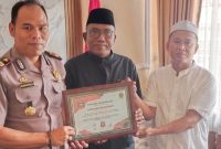 Fatha dan Lutfi Rizal Ormas Madas Nusantara DPK Kecamatan Pagantenan saat memberikan piagam penghargaan kepada Kapolsek Pagantenan. Senin, 29/02026.