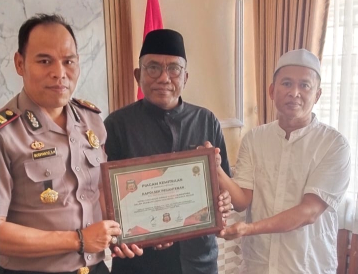Fatha dan Lutfi Rizal Ormas Madas Nusantara DPK Kecamatan Pagantenan saat memberikan piagam penghargaan kepada Kapolsek Pagantenan. Senin, 29/02026.