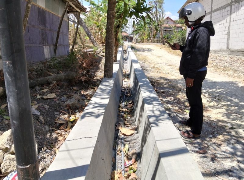 Caption: Seorang Wartawan Saat Berada di Lokasi Proyek Saluran Drainase di Desa Baruh, Sumber Anggaran Tak Jelas (Sumber Foto: Agus Junaidi/Pilar Pos)